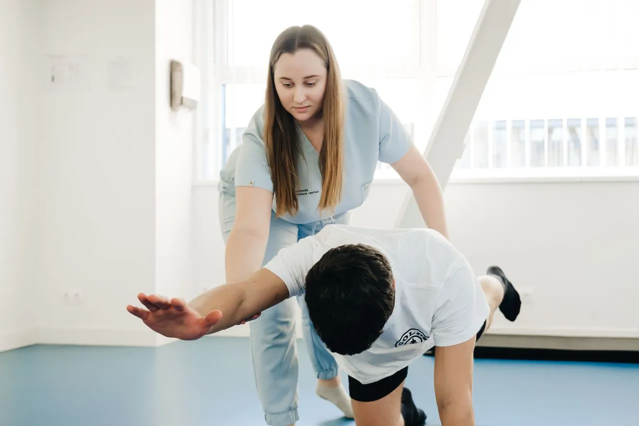Physiotherapist guiding a patient through a balance and stretching exercise