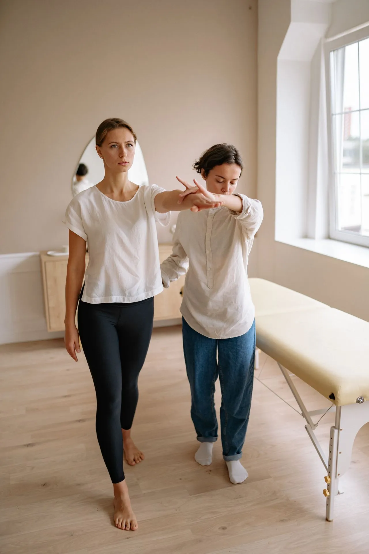 Therapist guiding a patient’s arm movement while standing