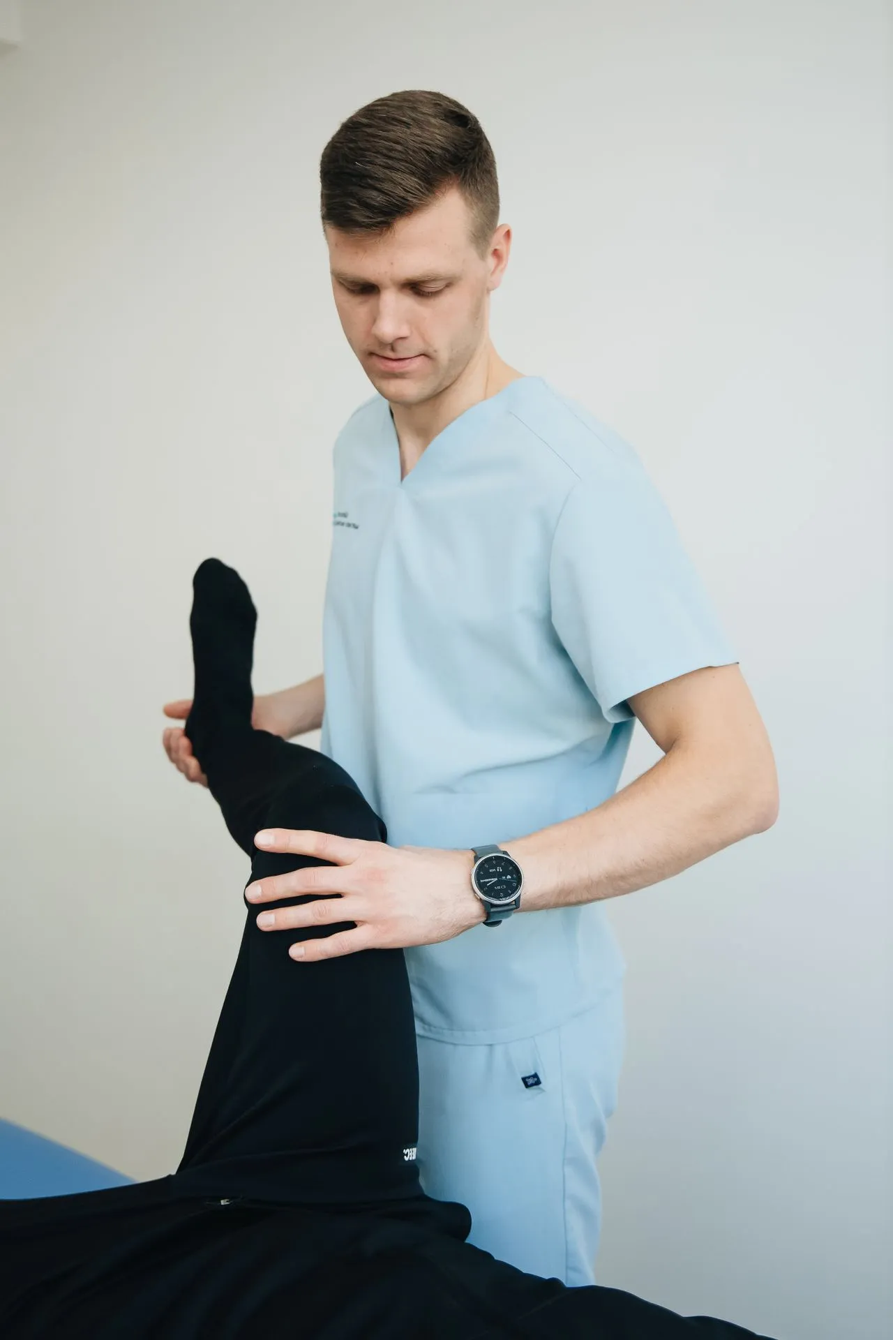 Physiotherapist stretching a patient’s leg